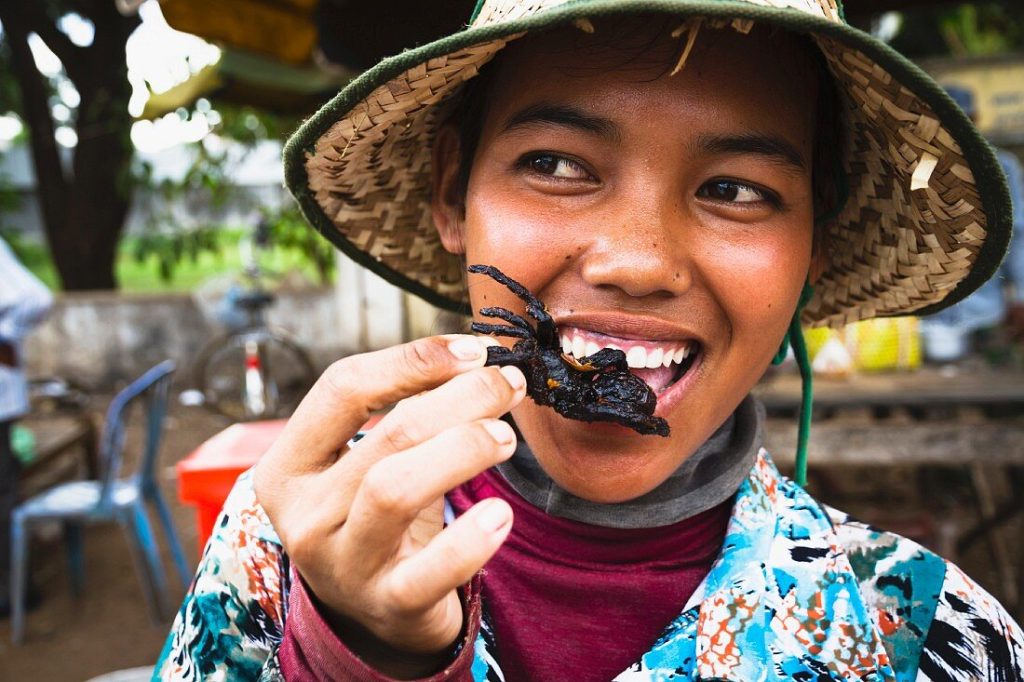 Frau isst gebratene Vogelspinne, Kambodscha